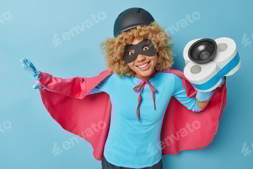 Preview: Horizontal shot of positive female superhero holds plunger with toilet paper around wears protective