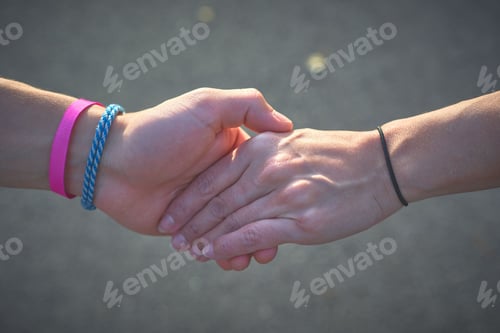 Preview: Closeup shot of two people holding hands
