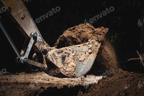 Preview: Closeup of a backhoe loader equipment picking scraps and soil from underground by digging