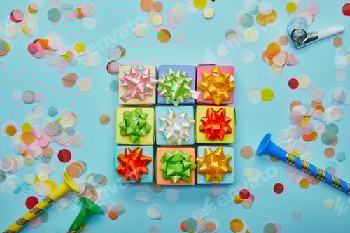Preview: Top view of colorful gifts with bows, party horns and confetti on blue background