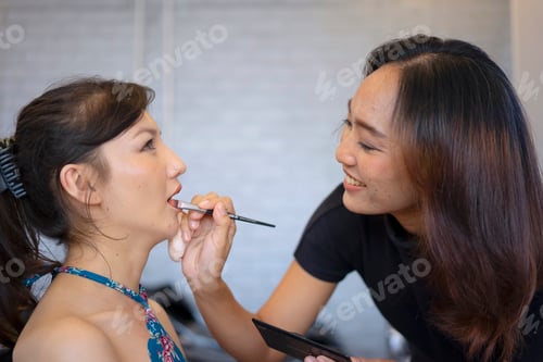 Preview: Young woman is make up her face at beauty salon.