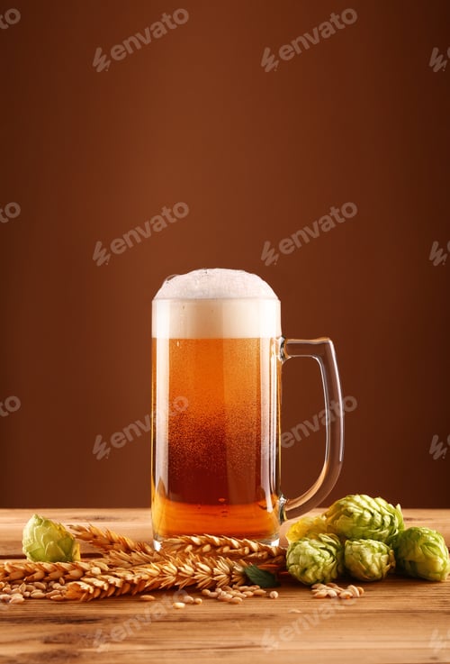 Preview: Close up beer glass, hops and barley over brown