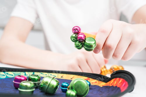 Preview: Little kid play toy sitting at table closeup. Hand of child magnetize and pick up colorful metal
