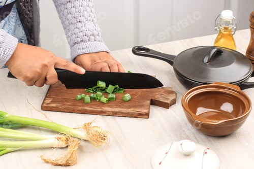 Preview: Woman working in the kitchen chopping up the vegetables.