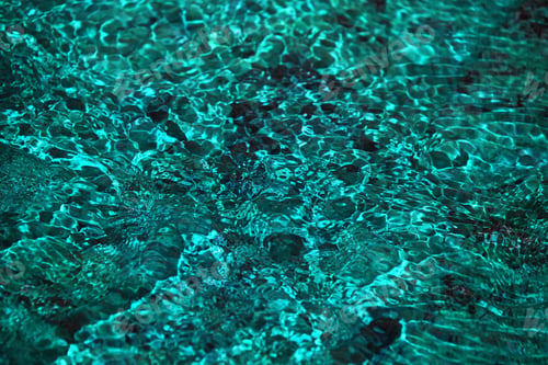 Preview: Running teal blue water waves over stones