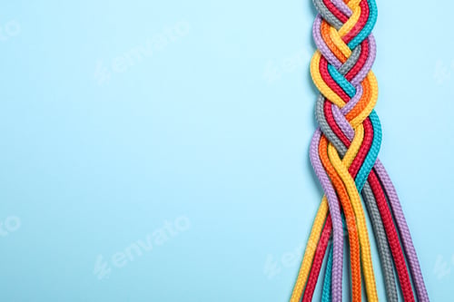 Preview: Top view of braided colorful ropes on light blue background, space for text. Unity concept