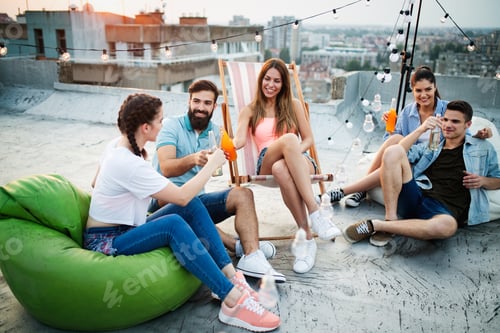 Preview: Group of happy young friends having party on rooftop