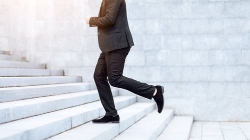 Preview: Closeup view of entrepreneur running up stairs, being late for work in busy city