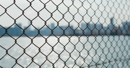 Preview: Metallic fencing at seaside in evening