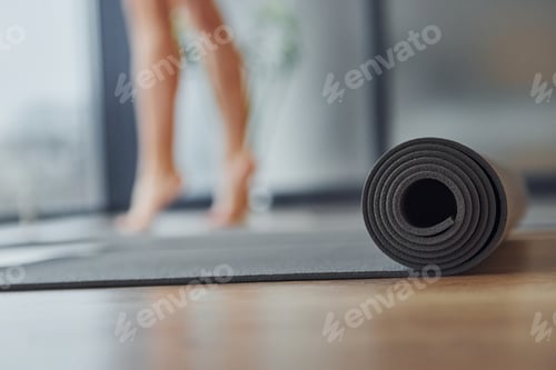 Preview: Rolled Yoga Mat on Wooden Floor Indoors