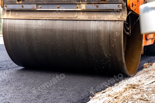 Preview: Machines are crushing the asphalt after pouring to make a road for cars.