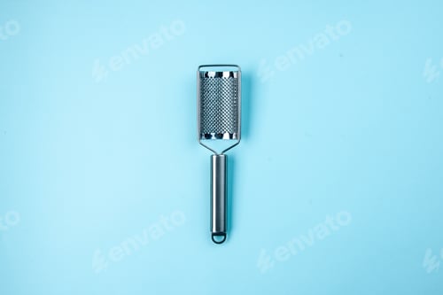 Preview: Above view of stainless kitchen tool lying in the middle on pastel blue background with free space
