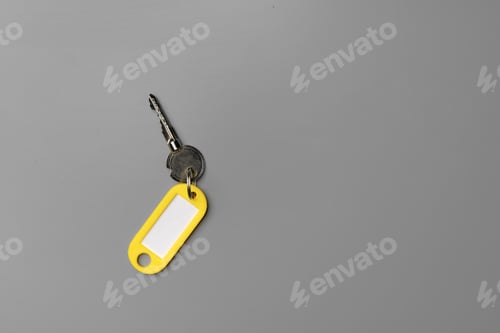 Preview: Door key with yellow tag on gray background