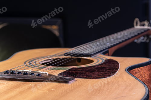 Preview: Close-up of a classical acoustic guitar on a black background.