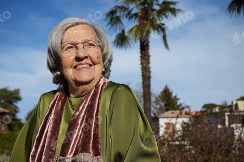 Preview: Elder cheerful grandmother enjoys in a garden