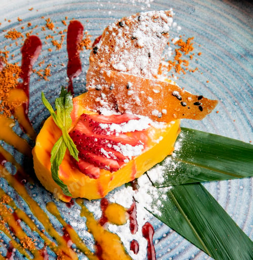 Preview: side view of mango cheesecake decorated with fresh strawberry sweet sauce