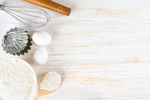 Preview: Baking ingredients flour, eggs, milk, bakeware on white wooden background with copy space