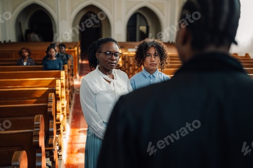 Preview: Mother and daughter listening to priest in church