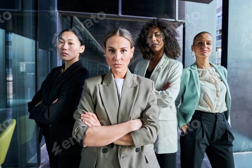 Preview: Four multiracial empowered women looking at camera confident and serious at the office.