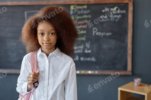 Preview: Black Girl Holding Backpack Posing Against Blackboard
