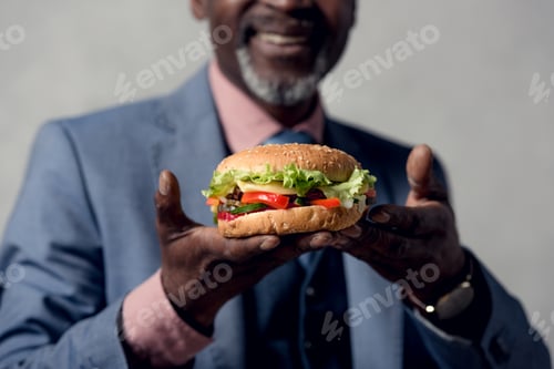 Preview: cropped view of african american man with hamburger
