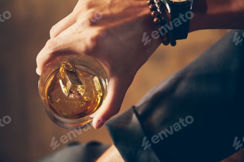 Preview: High angle closeup shot of a male holding a glass of whiskey