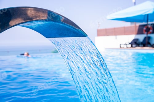 Preview: Empty Swimming pool with waterfall jet, jacuzzi in action.Spa and wellness center.Seaside vacation