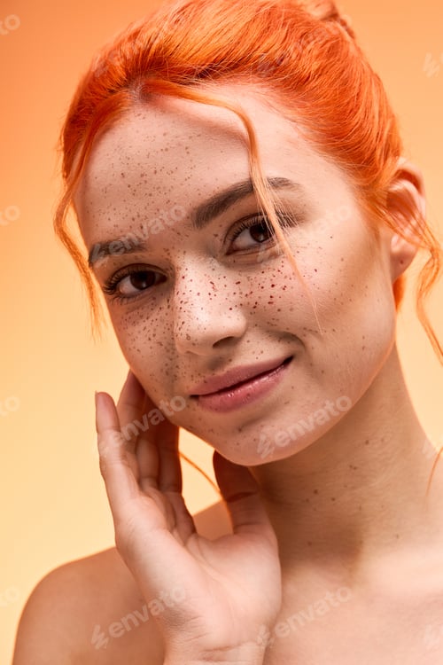 Preview: Stylish young woman with vibrant orange hair and natural makeup shares a joyful moment