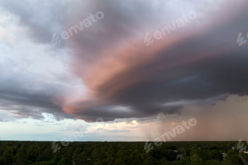 Preview: Dark stormy clouds forming on gloomy sky before heavy rainfall over suburban town area