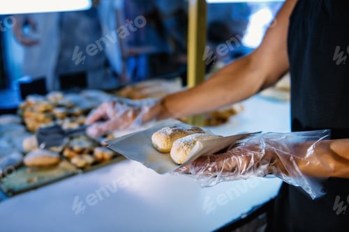 Preview: Female Shop Assistant In Bakery Serving Customer