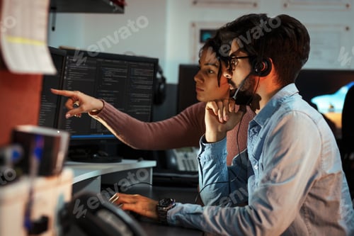Colleagues Reviewing Code Together in Modern Office