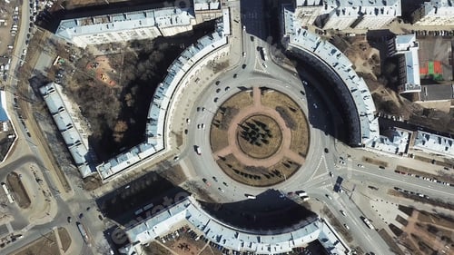 Preview: Top view of roundabout in city center. Roundabout with busy traffic of cars, surrounded by houses in