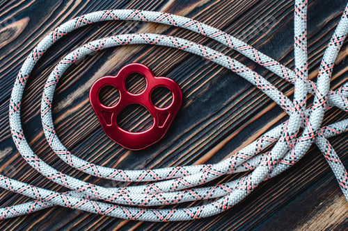 Preview: Detailed view. Isolated photo of climbing equipment. Parts of carabiners lying on the wooden table