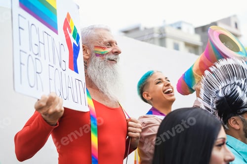 Preview: Happy senior gay man holding banner at pride lgbt festival - Focus on left face