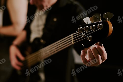 Preview: Unrecognizable Man Tuning Bass Guitar