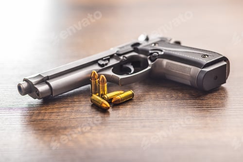 Preview: Handgun and bullets on wooden table.