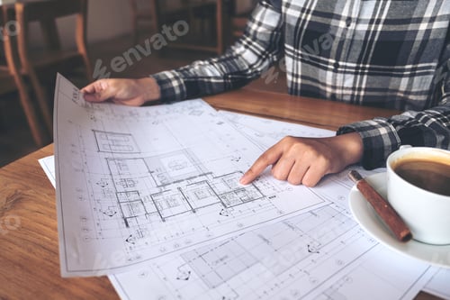Preview: An architect working and pointing at shop drawing paper on table