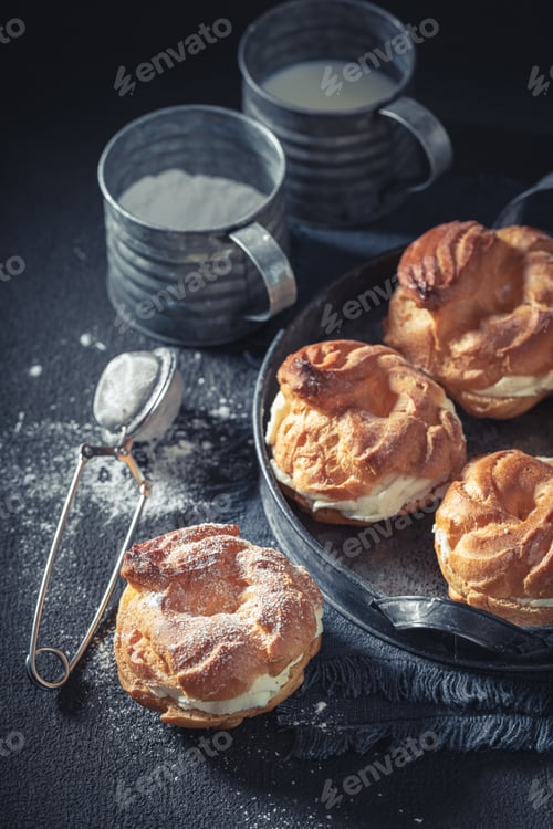 Preview: Yummy and sweet cream puffs on old metal plate