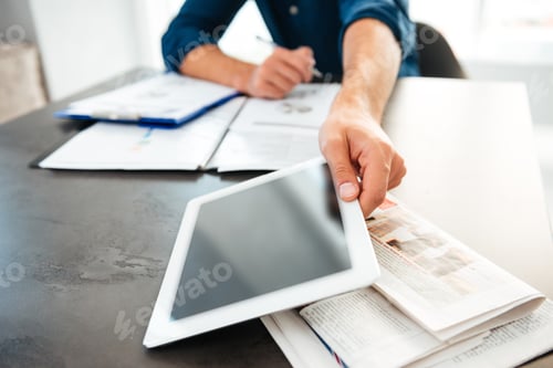 Preview: Cropped picture of young man's hands holding tablet