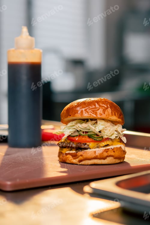 Preview: close-up of a ready-made large burger with beef in the kitchen of establishment lying on the table