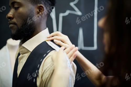 Preview: Tailor Taking Measurement of Man's Shoulder