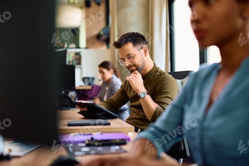 Preview: Young entrepreneur using digital tablet while working in the office.