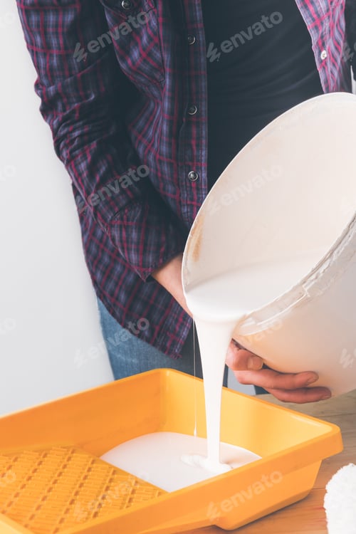Preview: cropped image of girl pouring white paint into plastic tray