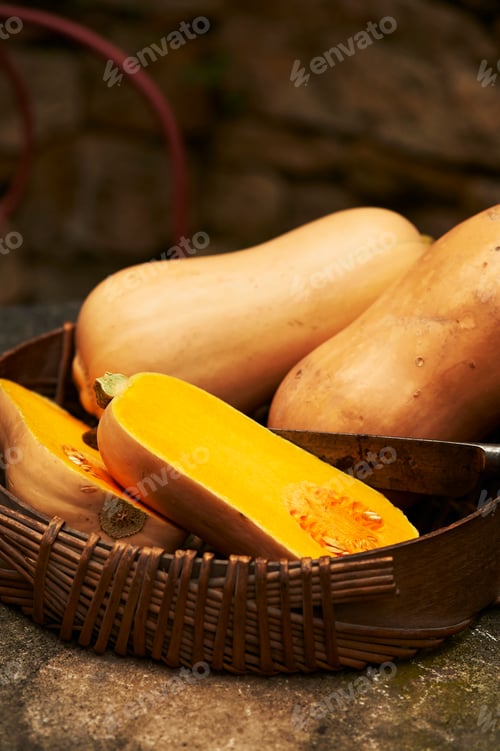 Preview: High angle view of halved and whole butternut squash in wick basket