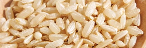 Preview: A background of dry brown rice grains showcases the integral, uncooked texture