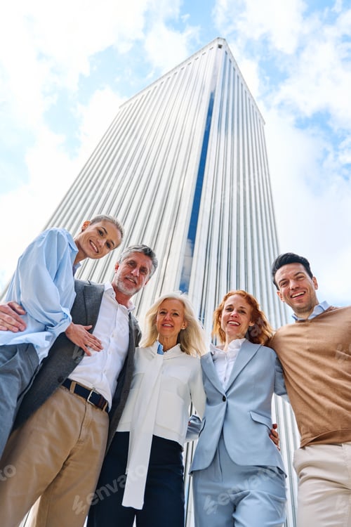 Preview: Business people looking at camera while embracing outdoors