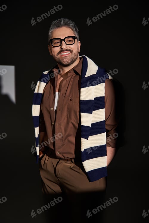 Preview: Stylish man showcases elegant fashion in a modern studio setting with trendy ensemble