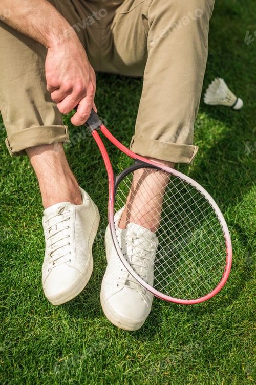 Preview: cropped shot of man holding badminton racket in hand