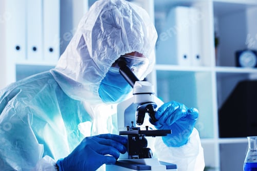 Preview: Medical worker in protective gown looking in microscope