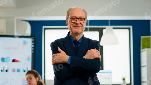 Preview: Elderly businessman looking at camera crossing arms and smiling